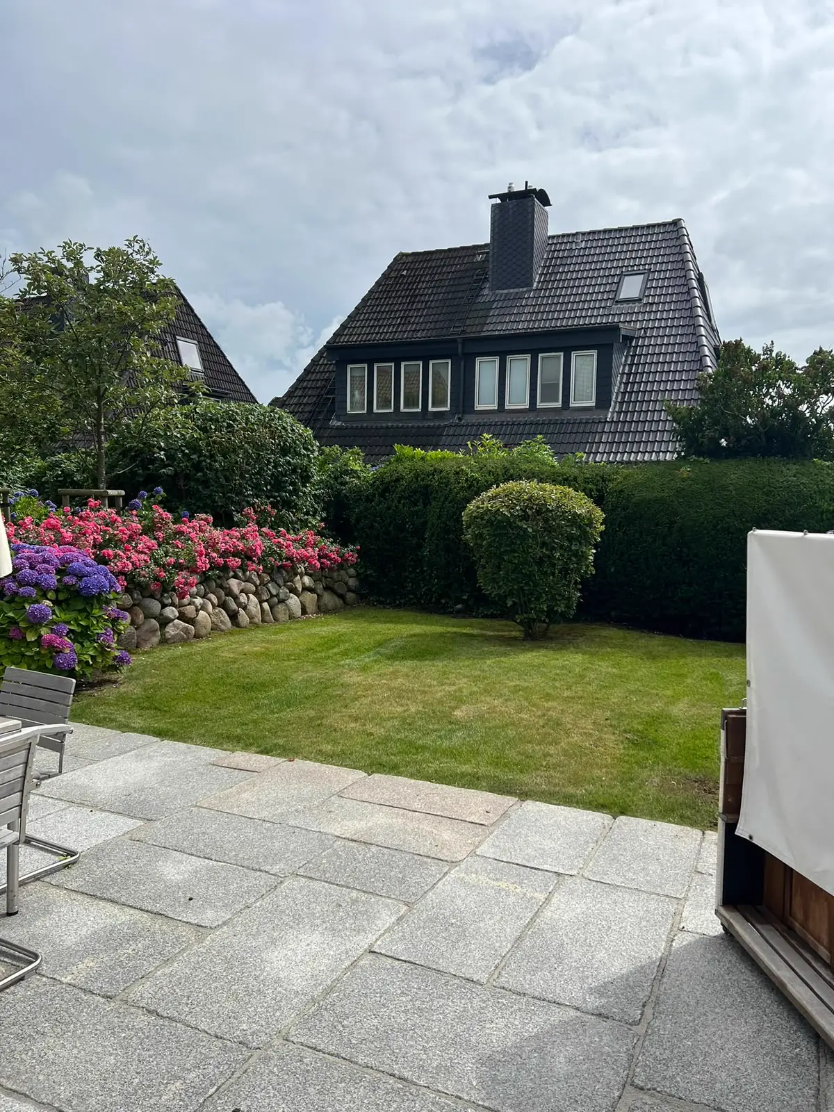 Hortensienbeet und Rasenfläche an einer Terrasse